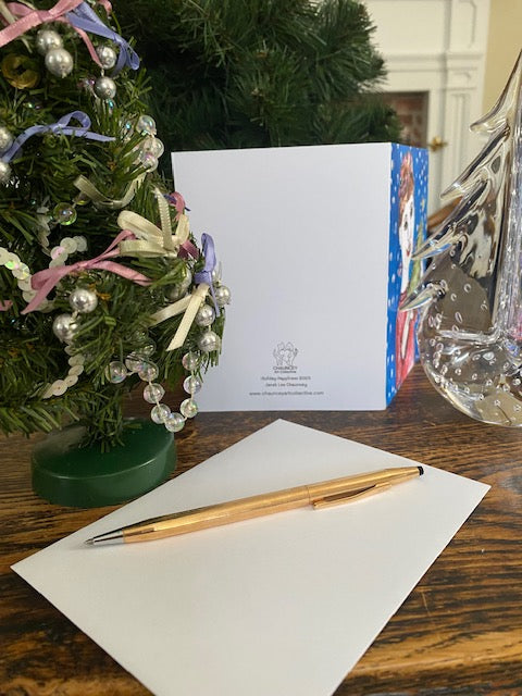 Decorative wreath with a card, pen, and water bottle on a wooden surface.