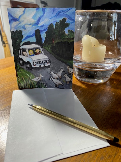 Front of Pavement Patrol card with its envelope and a gold pen on a wooden table.