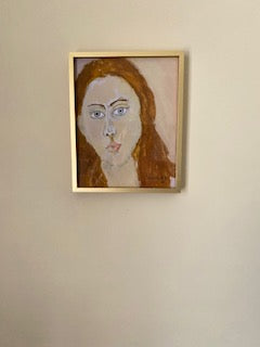 Gold framed mockup of "Portrait Girl art print hanging on beige colored wall.