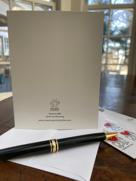 The rear of the greeting card is shown once more with the envelope, a pen and stamps.