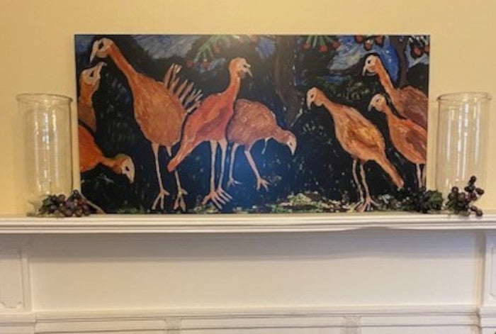 Mockup of the metal print titled Turkey Talk.  It is resting on the mantle with two hurricane lamps on either side and a bureau in front of the h