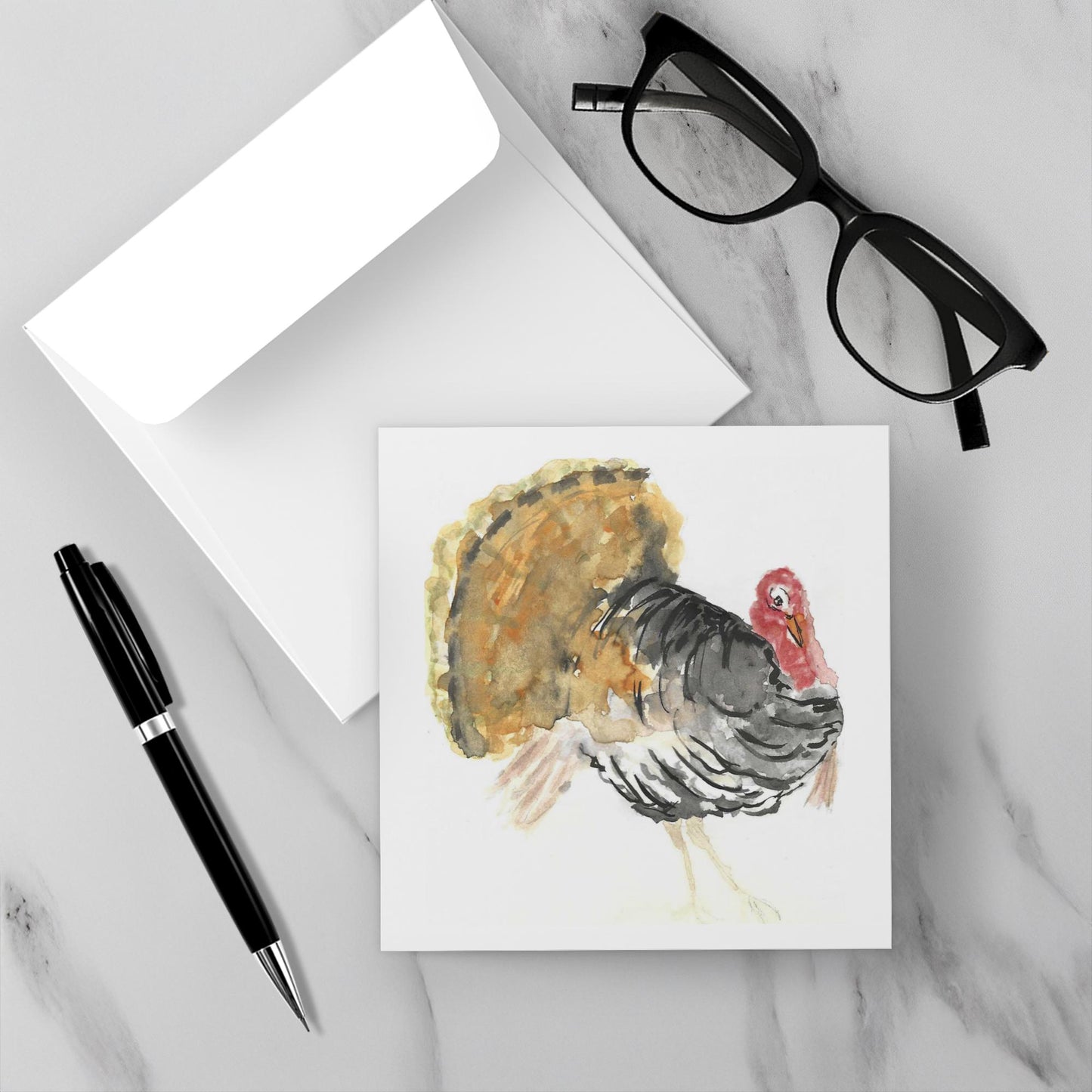 Card with a turkey illustration on a marble surface with glasses and a pen.