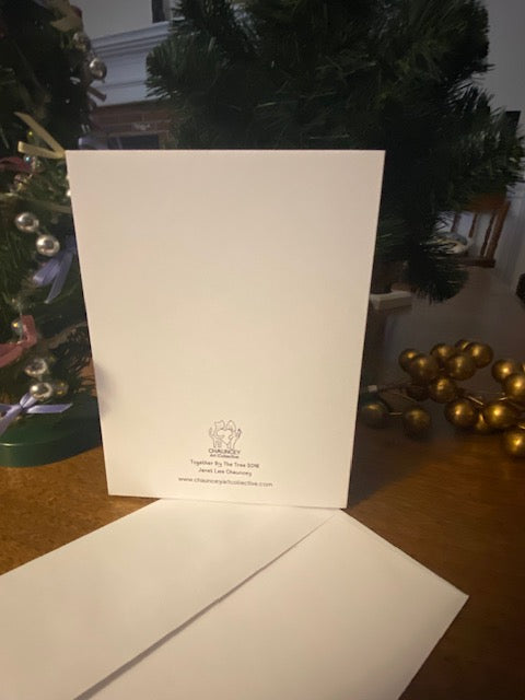White card with title Together By The Tree and Chauncey Art Collective's logo on a wooden surface with decorative items in the background