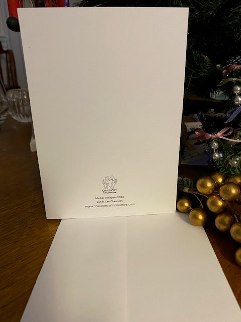 White card with a logo on a wooden surface with decorative items in the background