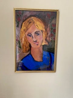 Close up mockup of Yellow Haired Girl art print in a gold frame on a white wall. The colors in the print are vivid.